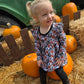 Child in a spooky floral peplum top with ruffles. Top is handmade for spooky kids. 
