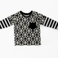 Black and white layered t-shirt. Main print is a checkerboard with skulls on it.  Long sleeves are black and white striped. 