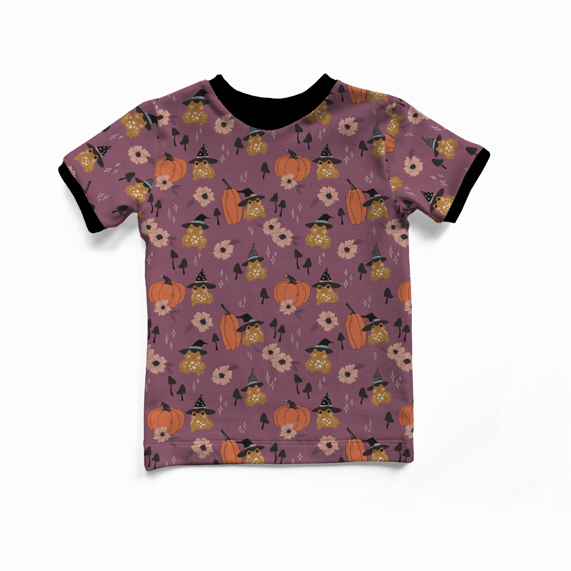 A toddler's short-sleeve ringer t-shirt with a purple base, featuring an all-over Halloween pattern of orange pumpkins, black-clothed ghosts, and yellow flowers. It has black ribbed collar and sleeve cuffs, shown against a plain white background.