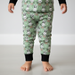 Child wearing green pajama pants with bunny pattern on a plain background