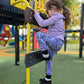 A child wearing spooky floral purple leggings at a playground. Leggings are handmade in the US.