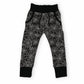 Black and white spiderweb patterned jogger pants for toddlers, featuring an elastic waistband and ribbed ankle cuffs, shown against a plain white background.