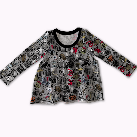 Long-sleeve peplum top, grey with spooky designs on it : pumpkins, skulls, pentagrams, coffins, ghosts