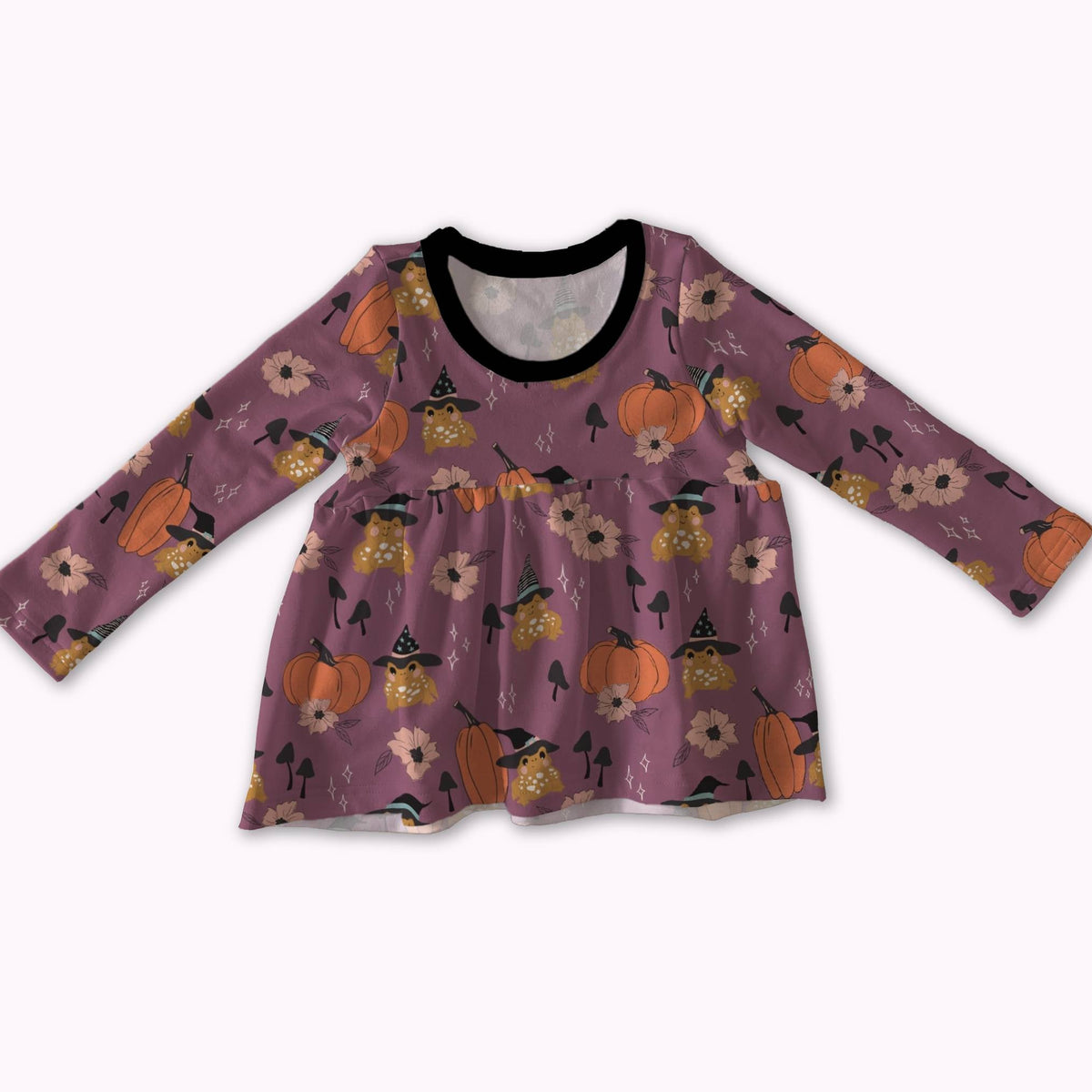 A long-sleeve baby dress in a dusty purple color, decorated with a Halloween pattern of orange pumpkins, black witch hats, and white flowers. It features a black ribbed crew neck and is displayed against a plain white background.