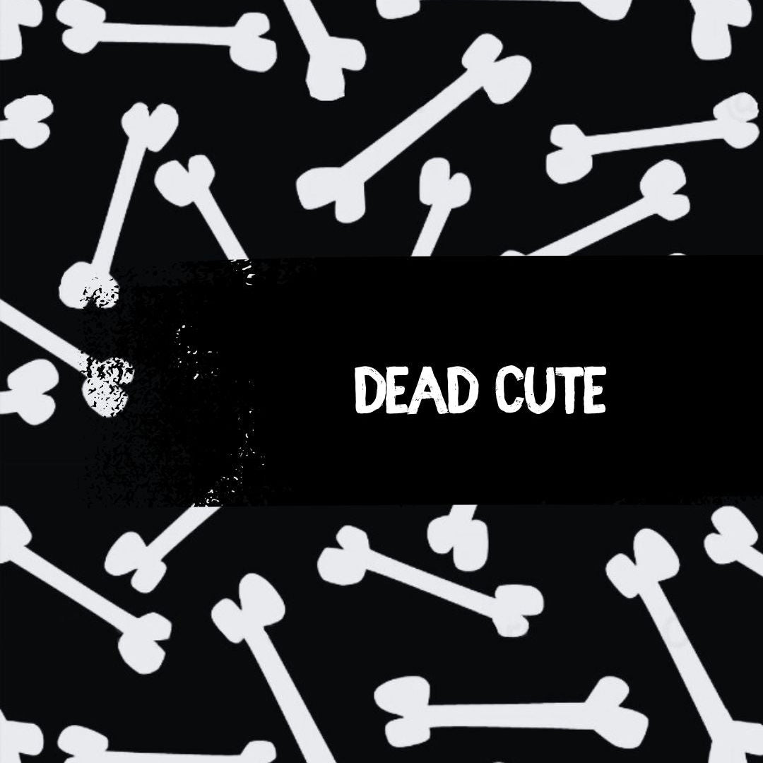 Black background with white bone pattern and 'DEAD CUTE' text