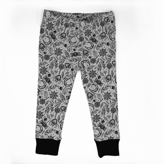 Spooky cute leggings, white with black designs : spiderwebs, spiders, bats, leaves, moons, and candies. Black cuffs at legs. Elasticat at waistband. 